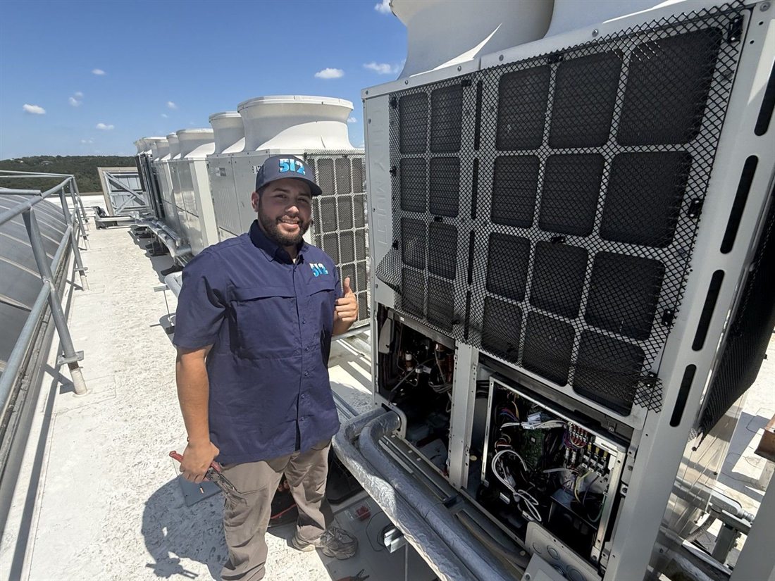 512 Mechanical technician servicing a VRF condensing unit on a commercial rooftop in Austin, Texas